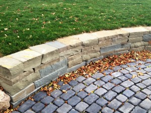 block wall seperateing a paver brick walkwya from the yard